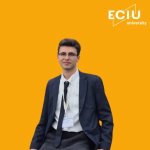 A Man with glasses wearing a suit in a yellow background